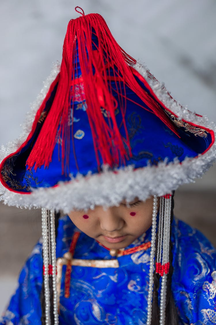 Girl Wearing A Blue Hat With Red Tassel