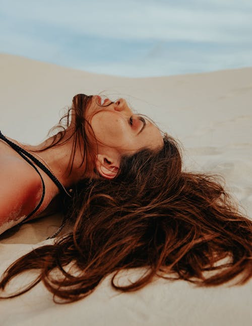 Woman in Red Bikini Lying on Sand