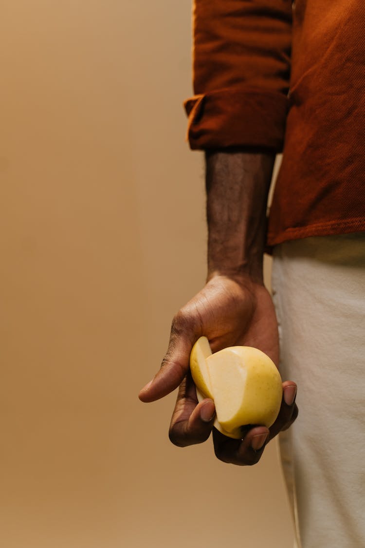 A Person Holding A Sliced Pear