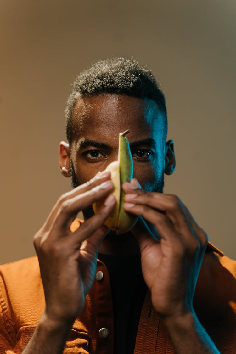 A Man Holding Fruits Cut In Half