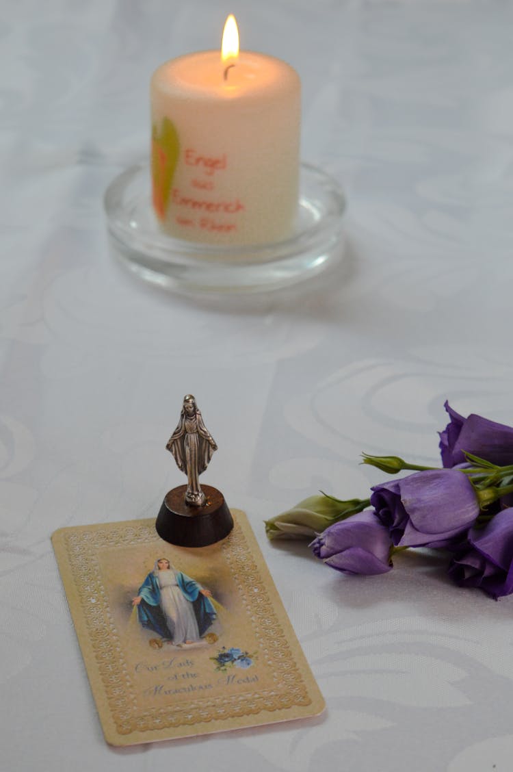 A Small Figurine On Top Of A Card With Printed Image