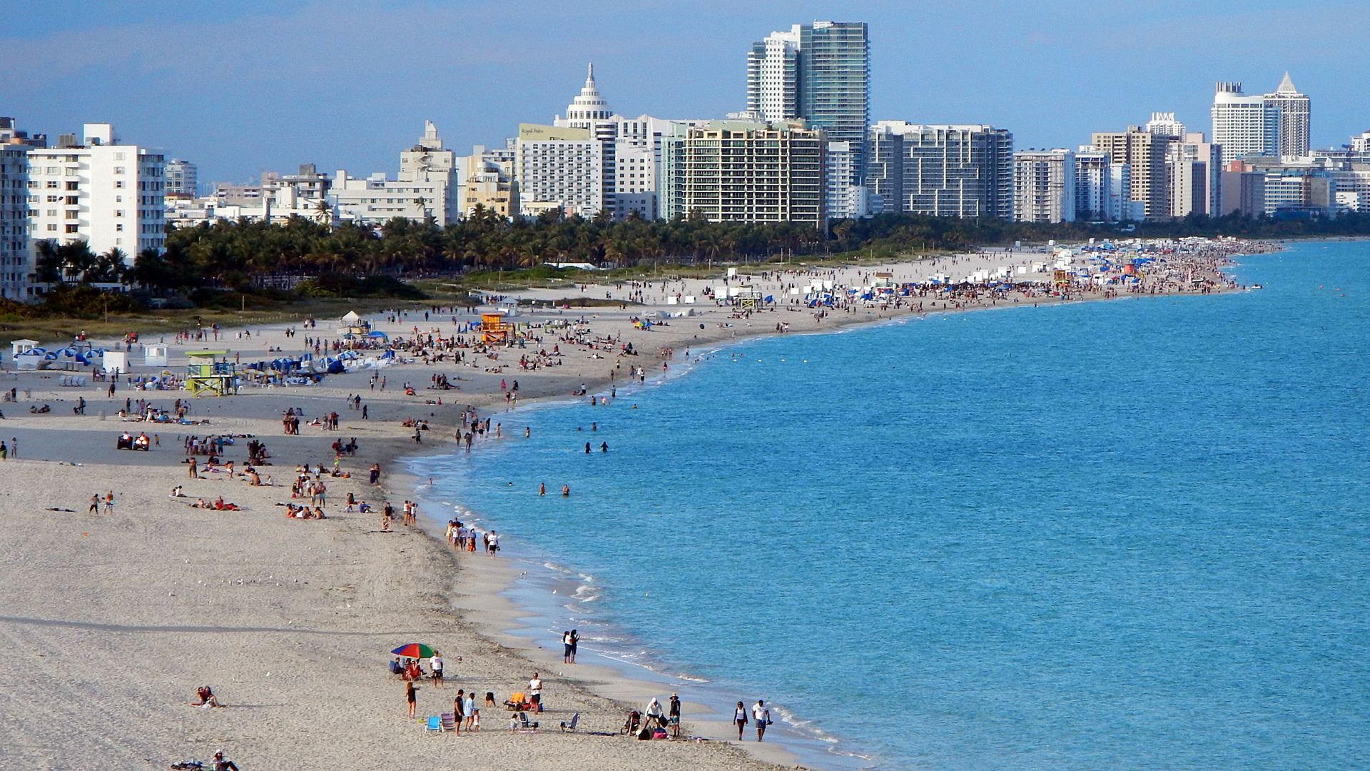 South Beach Miami coastline with oceanfront hotel skyline, turquoise water and crowded white sand