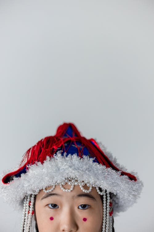 A Girl Wearing a Traditional Hat with Pearls