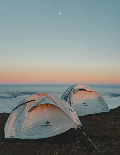 Free Two tents on a hilltop with a scenic view under a twilight sky, perfect for adventure lovers. Stock Photo