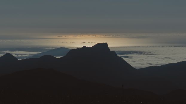 Tranquil mountain silhouette with cloudscape during twilight. Ideal for nature and travel themes.