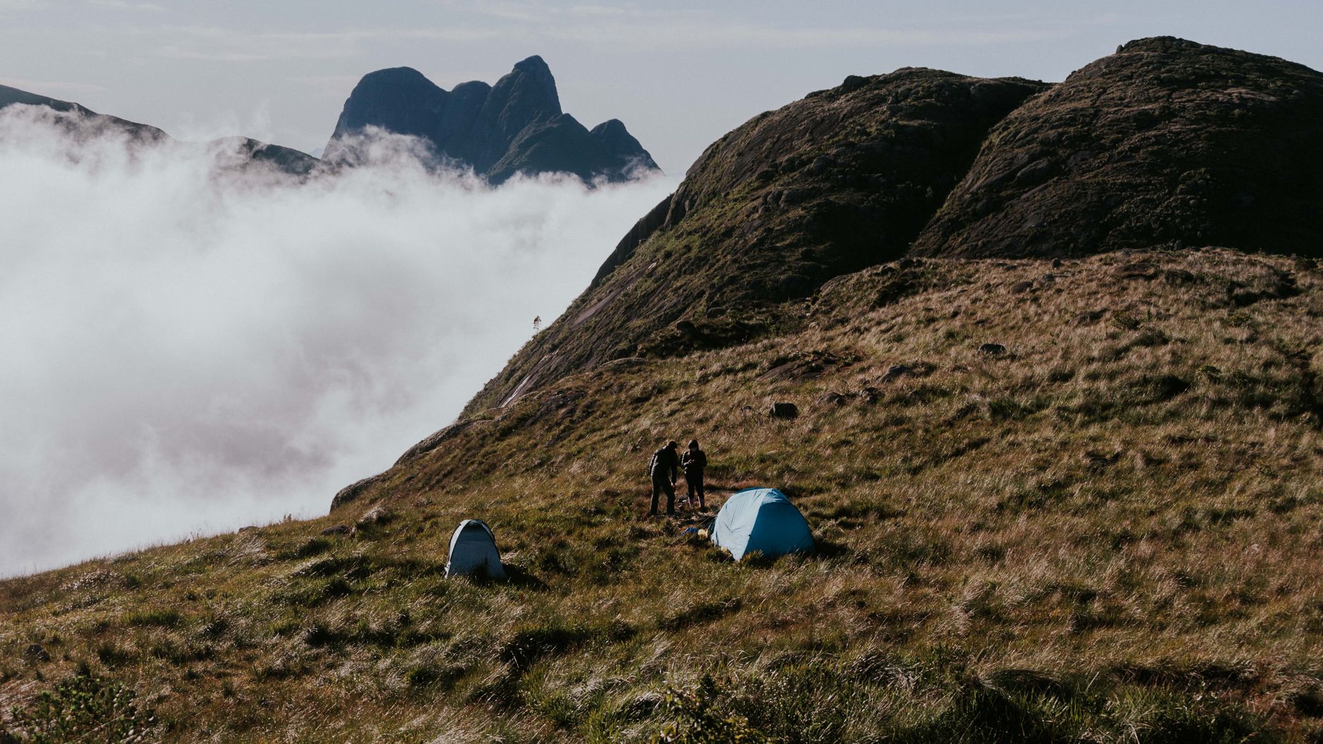 hiker setting up tent wilderness