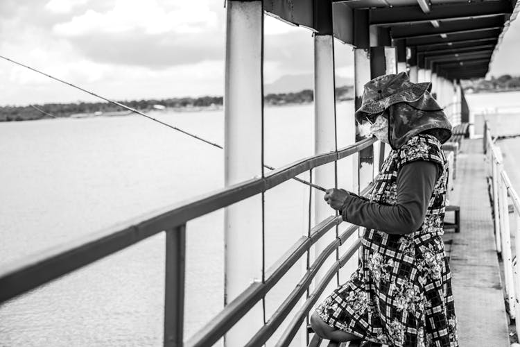 Woman Fishing On A Bridge In Black And White 