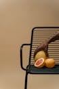 A Person Holding a Pomelo on a Steel Chair