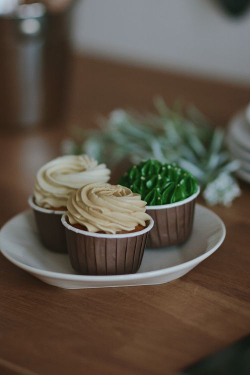 Free Three beautifully frosted cupcakes displayed on a white plate, perfect for dessert lovers. Stock Photo