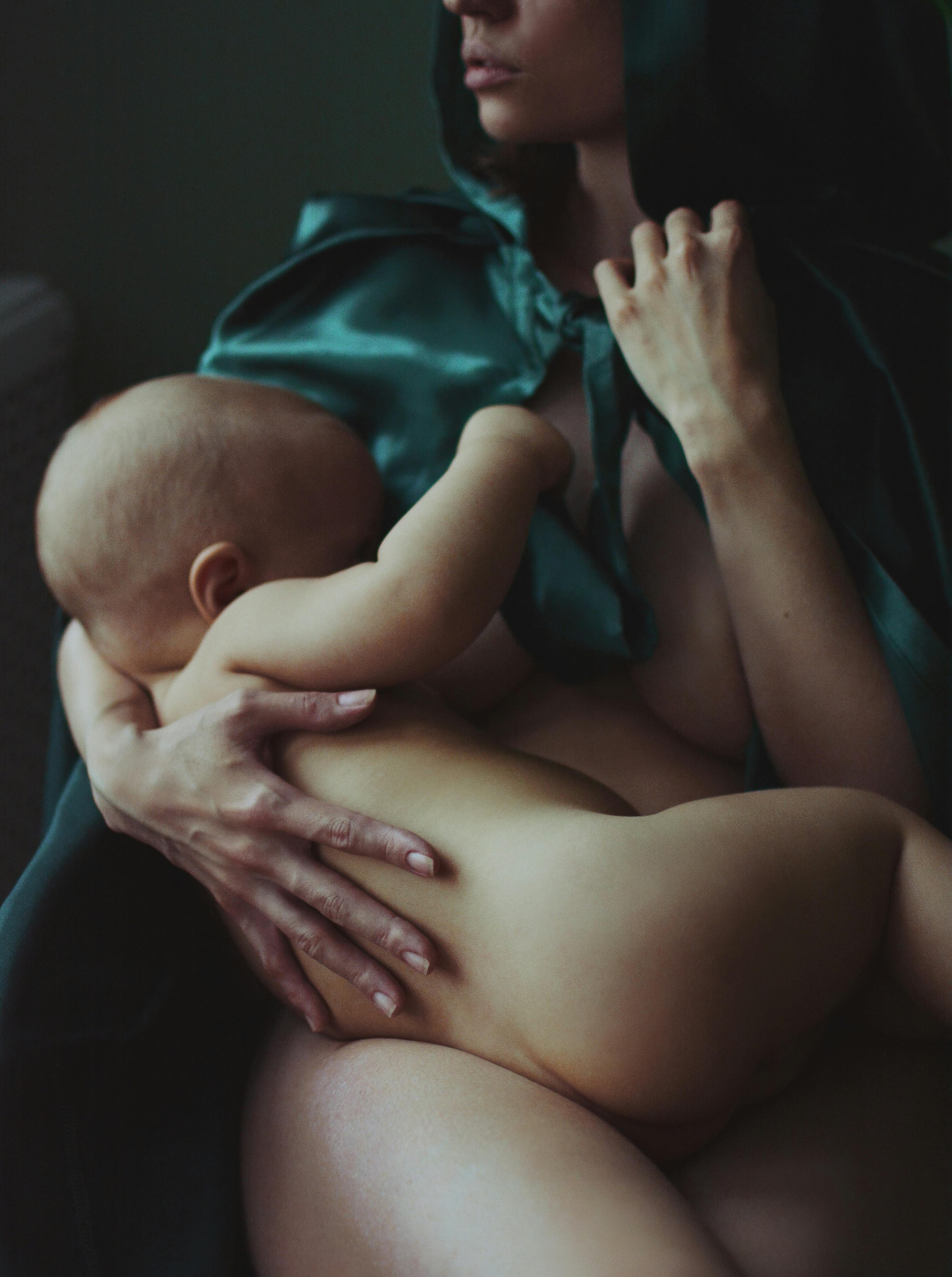 woman in green shirt carrying baby