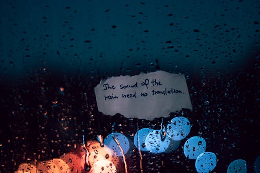 Rainy night scene with raindrops and handwritten inspiring note on glass.