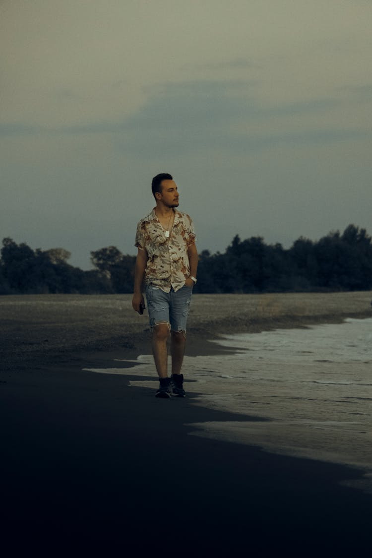 A Man Walking On Shore While Looking Sideways