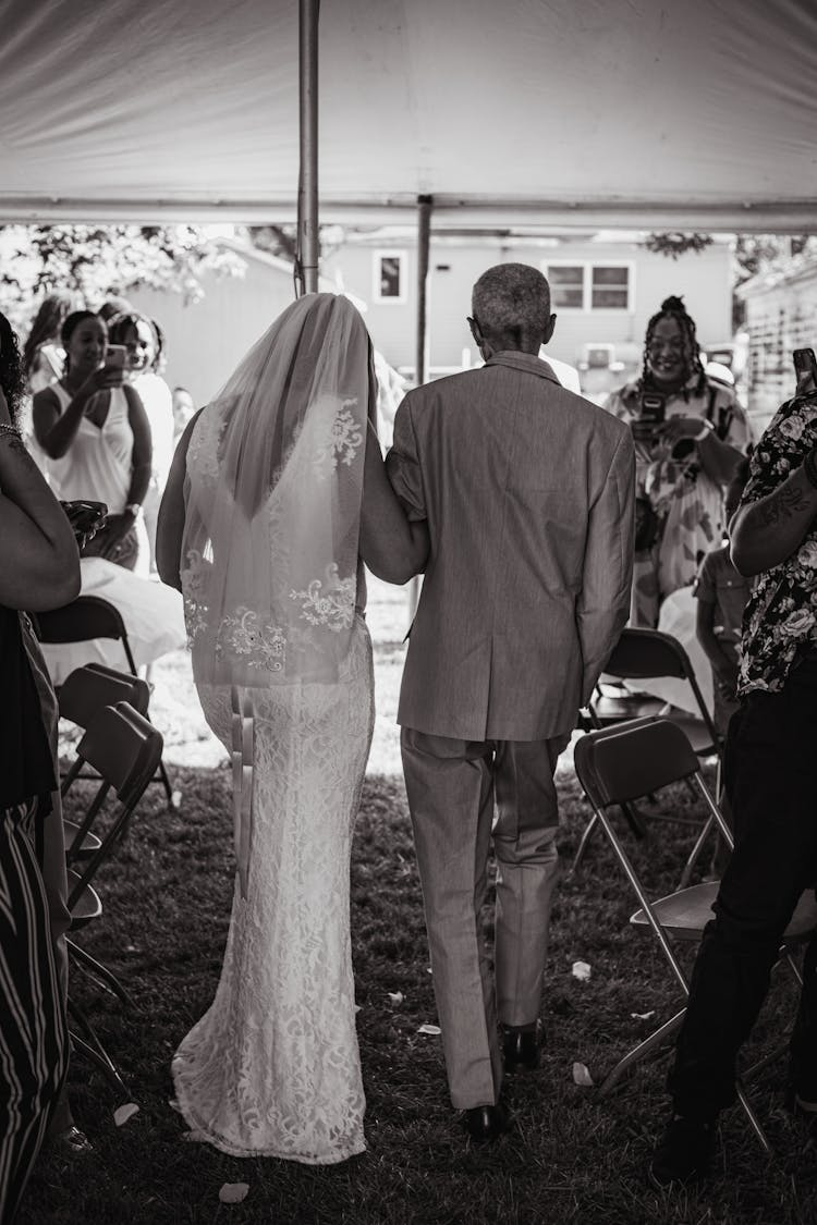 Grayscale Photo Of A Bride And Her Father Walking Together