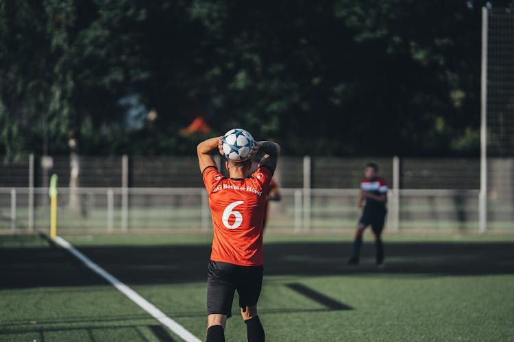 A Man Wearing A Jersey Throwing The Ball