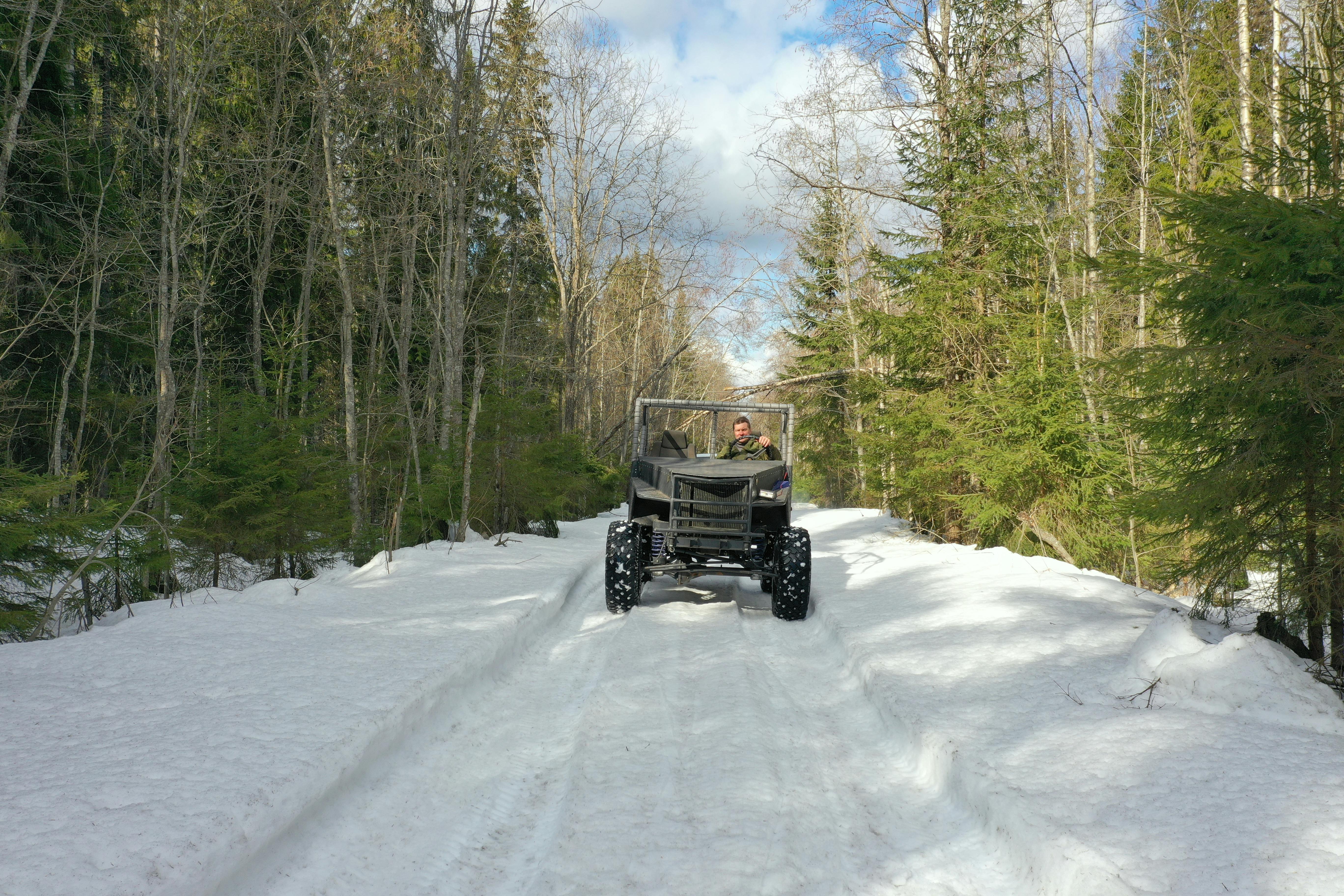 Jeep navigating through snowy forest in Karelia, Russia, during winter for an off-road adventure.