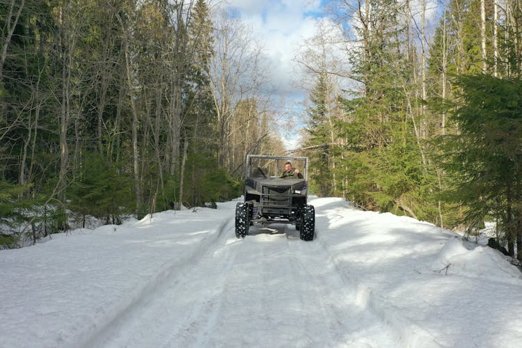 A Man Driving A Jeep On Snow Covered Road