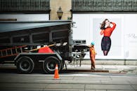 一名建筑工人正在城市街道旁的卡车边工作