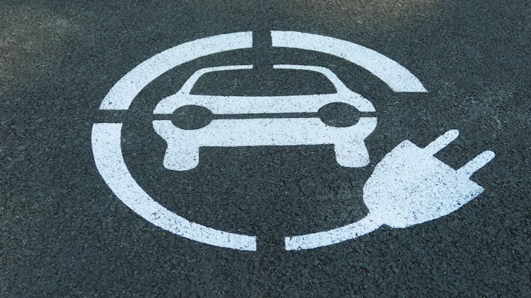 Logo For Electric Car Parking On Asphalt Road