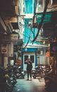 Man Standing on Concrete Road With Parked Motorcycles While Holding Dslr Camera