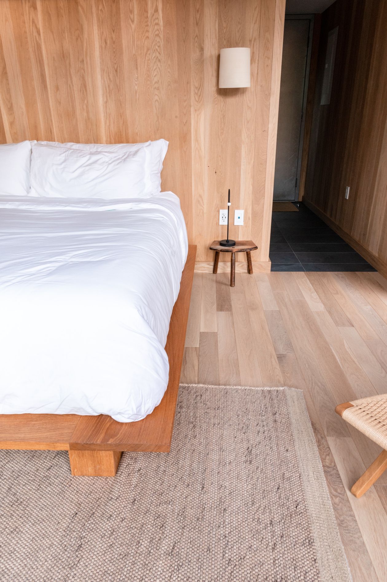 Jute rug laid beside a bed like a runner