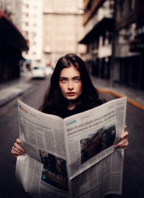 Free Woman in Gray Sweater Holding White Newspaper Stock Photo