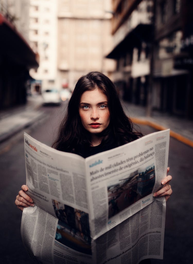 Woman In Gray Sweater Holding White Newspaper