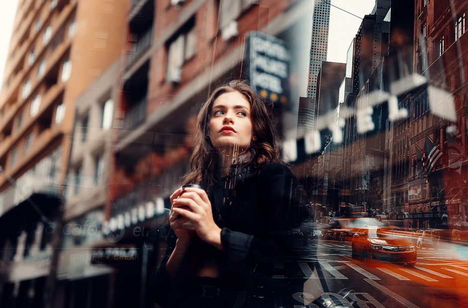 Double exposure image of a young woman in a cityscape, blending urban architecture and reflective elements.