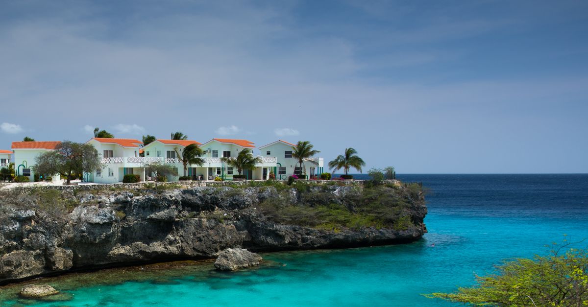 Oceanfront houses on a scenic cliff overlooking turquoise waters and blue sky.