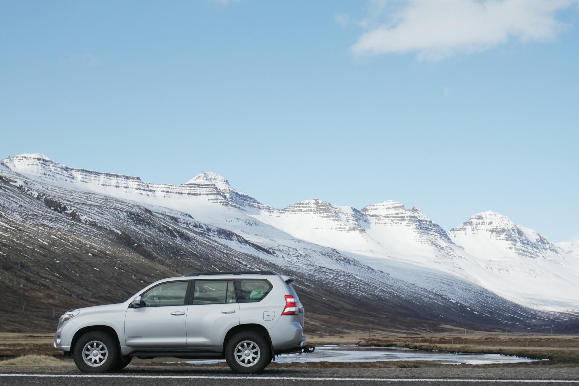 Gray Sports Utility Vehicle on Road Near Snow Covered Mountain