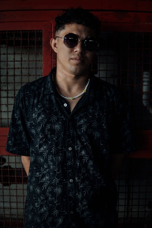 Man in a Black Floral Button Up Shirt Wearing Black Sunglasses