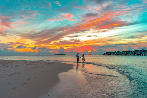 People Walking on Beach during Sunset