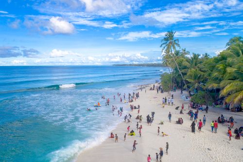 Free A lively beach scene with people enjoying the ocean and soft white sands in Fuvahmulah, Maldives. Stock Photo