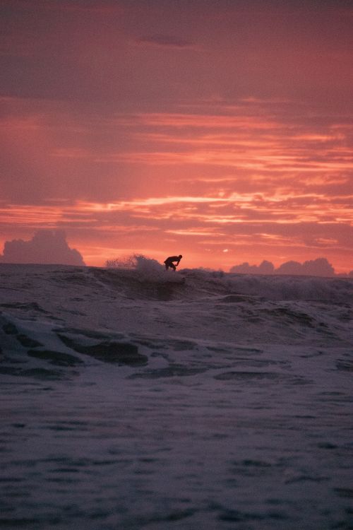 Free Dramatic sunset surfing silhouette at Puntarenas beach, perfect for serene adventure themes. Stock Photo