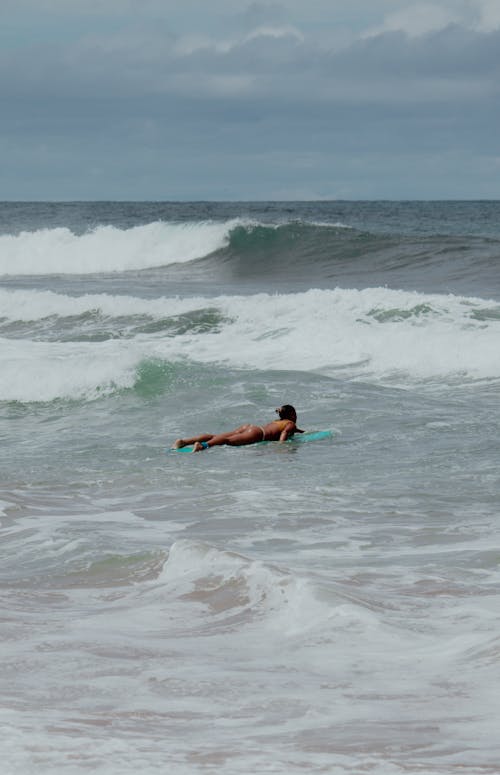 A Person Riding a Surfboard in the Sea