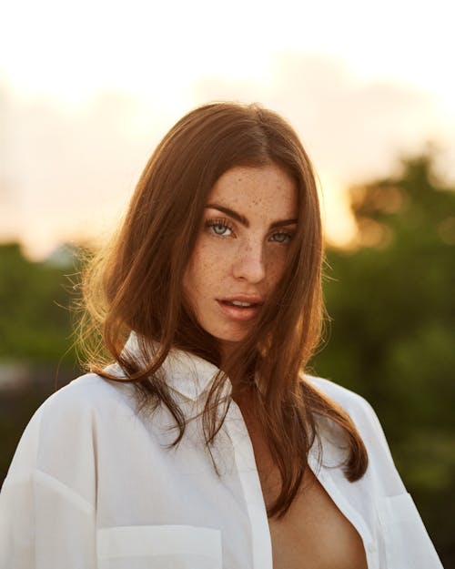 Portrait of a Woman in a White Button-Up Shirt Looking at the Camera