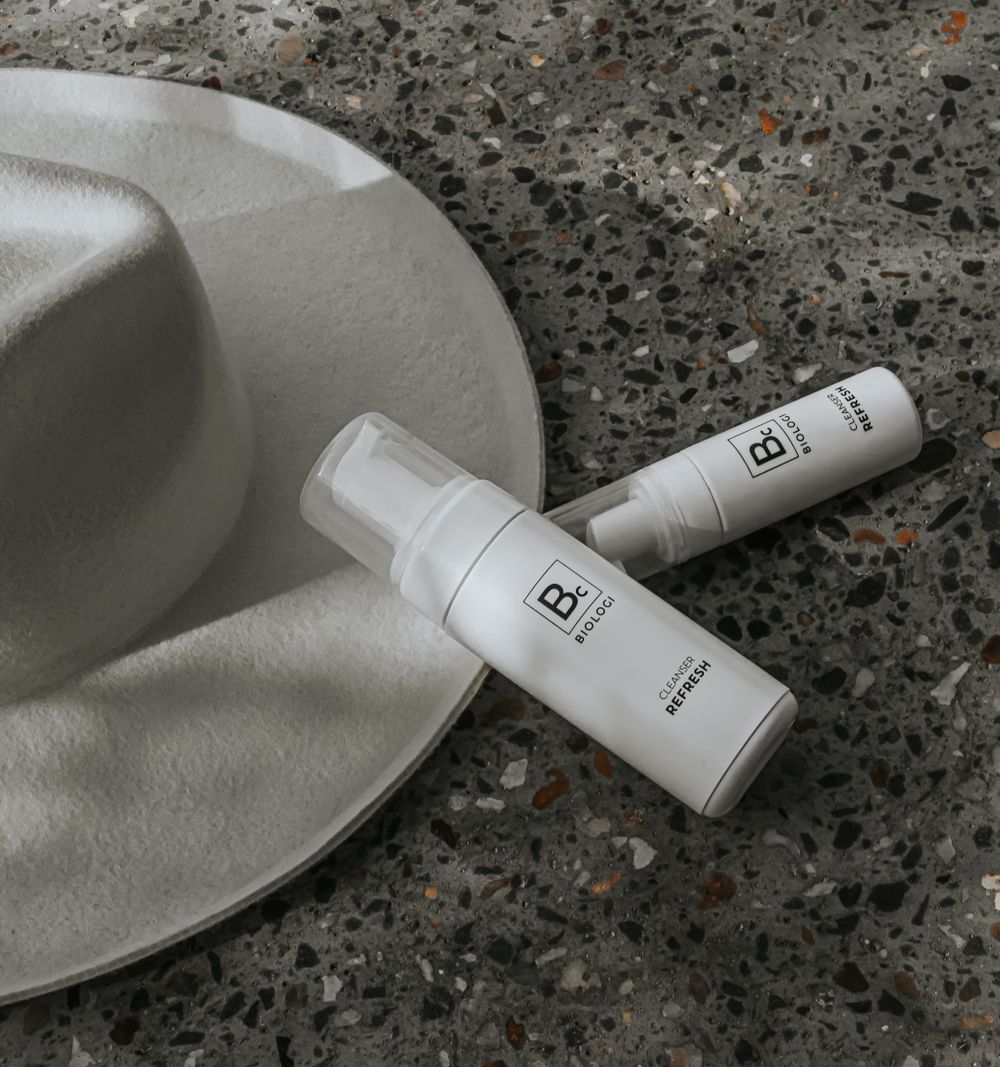 Minimal cosmetic bottles on textured surface