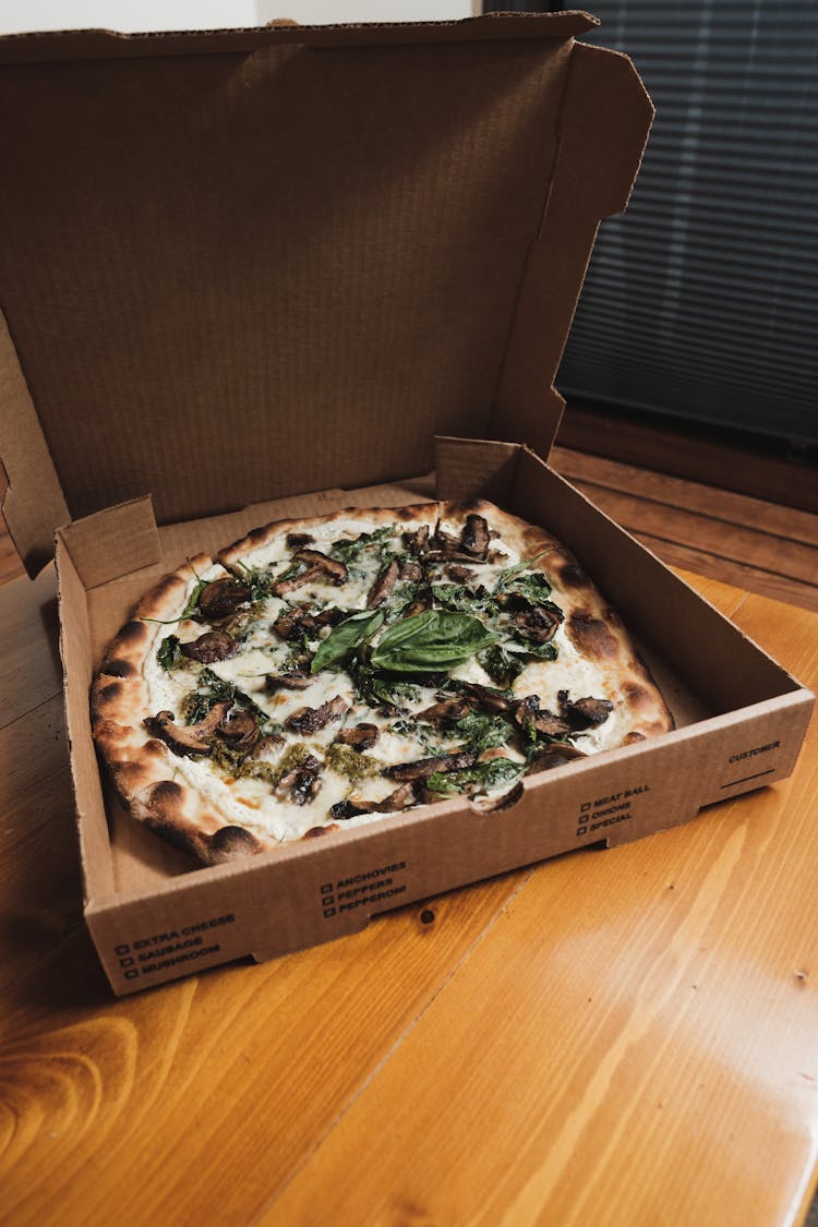 A Thin Crust Mushroom Pizza In A Cardboard Box