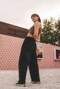 Woman in Black Pants Standing on Gray Concrete Floor