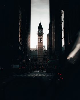 Dramatic silhouette of the Old City Hall clock tower in Toronto against a twilight sky.