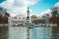 马德里雷池公园的阿方索十二世纪念碑旁，湖面上有人在划船