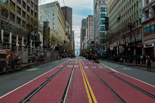 Urban scene in downtown San Francisco featuring colorful tram tracks and iconic architecture.