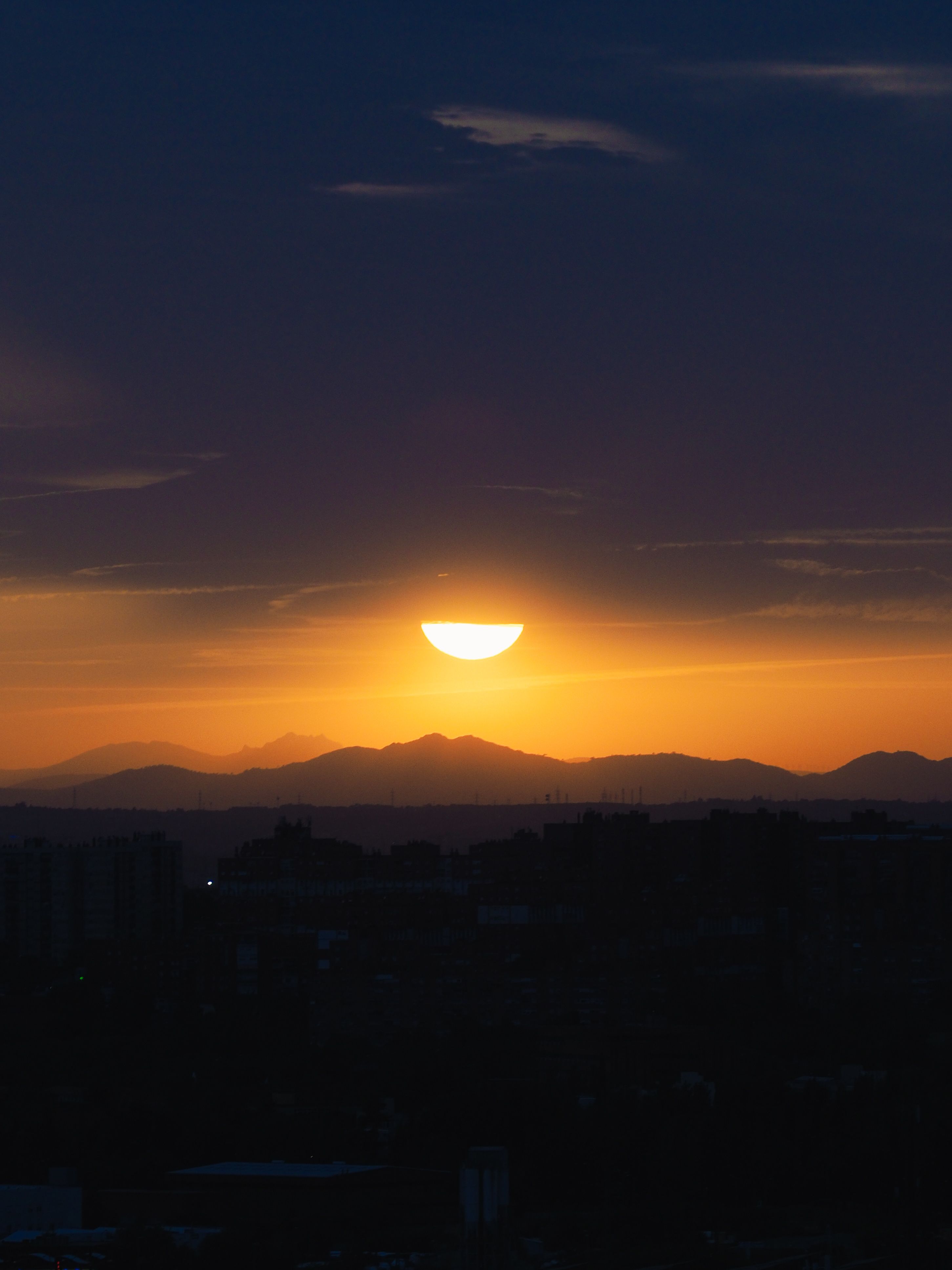 A Sun Setting Over the Silhouetted Mountains · Free Stock Photo