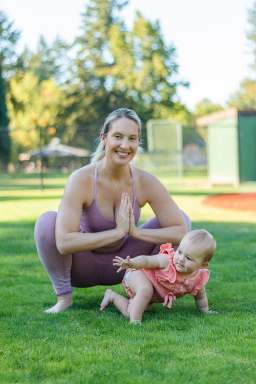 Shallow Focus of Mother and Her Baby on Green Grass
