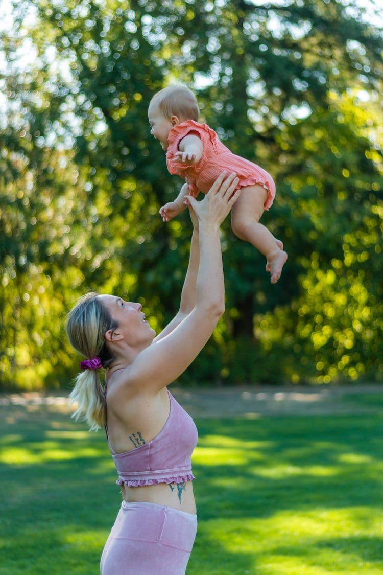 A Woman Throwing The Baby In The Air