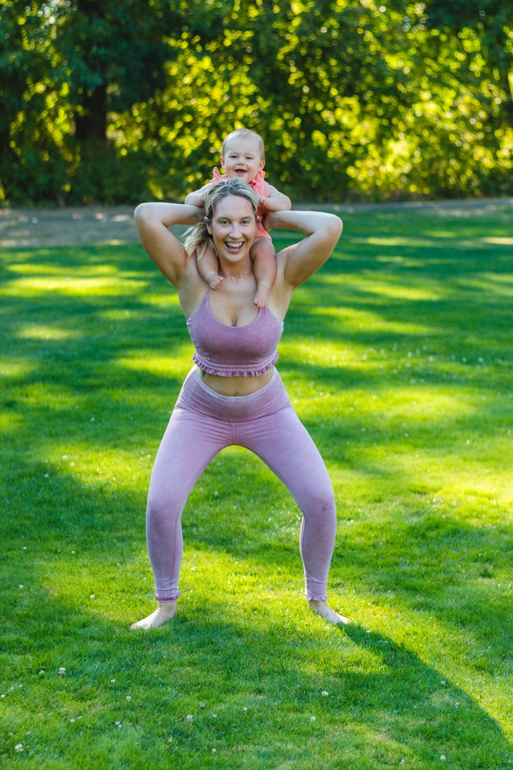 A Woman Carrying The Baby On Her Shoulders