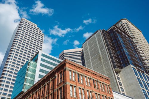 Free Low-angle view of diverse architecture with modern skyscrapers against a blue sky. Stock Photo