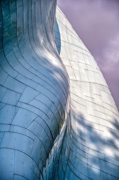 Artistic photo of a modern metal facade with sleek curves and unique shapes.