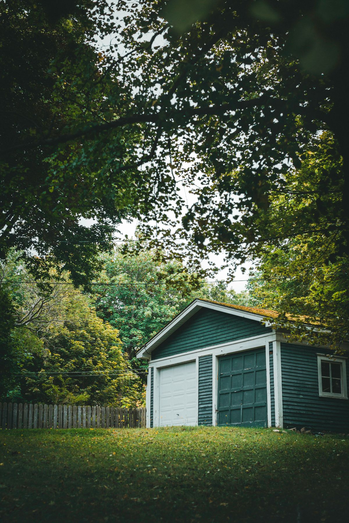 Wooden detached garage with a white door
