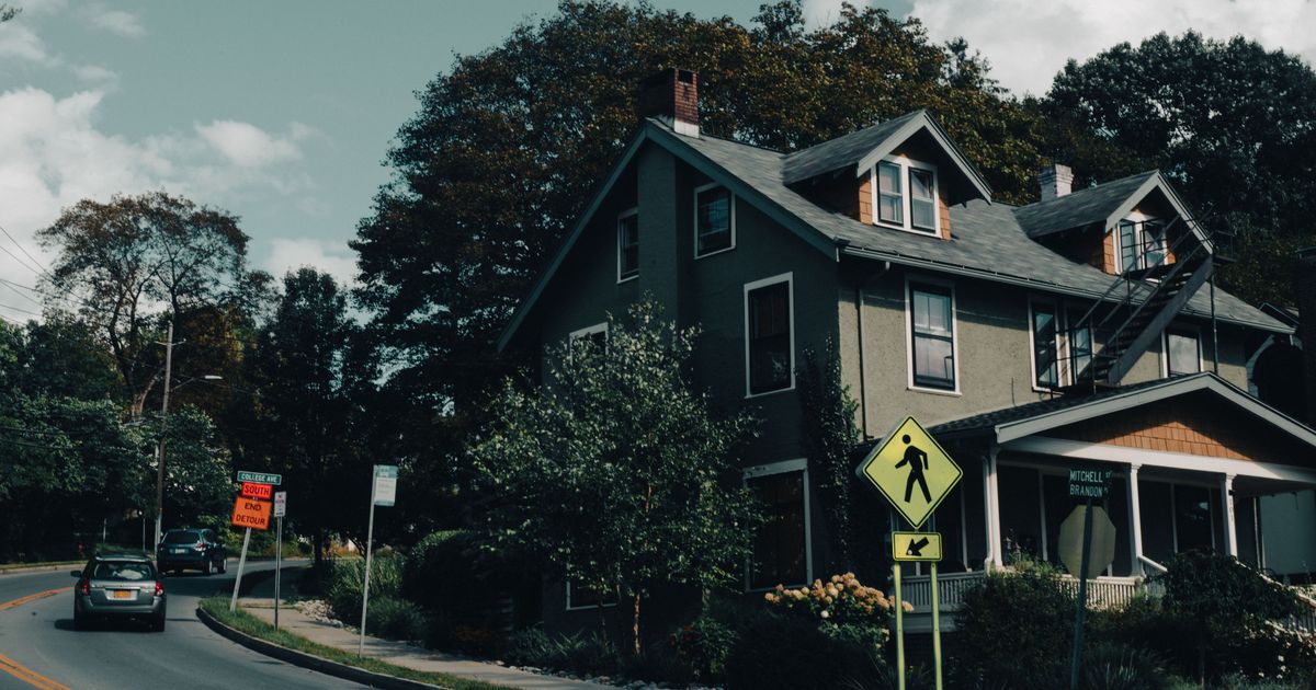 A suburban house on a quiet residential street under soft daylight