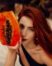 Woman in White Shirt Holding Sliced Orange Fruit